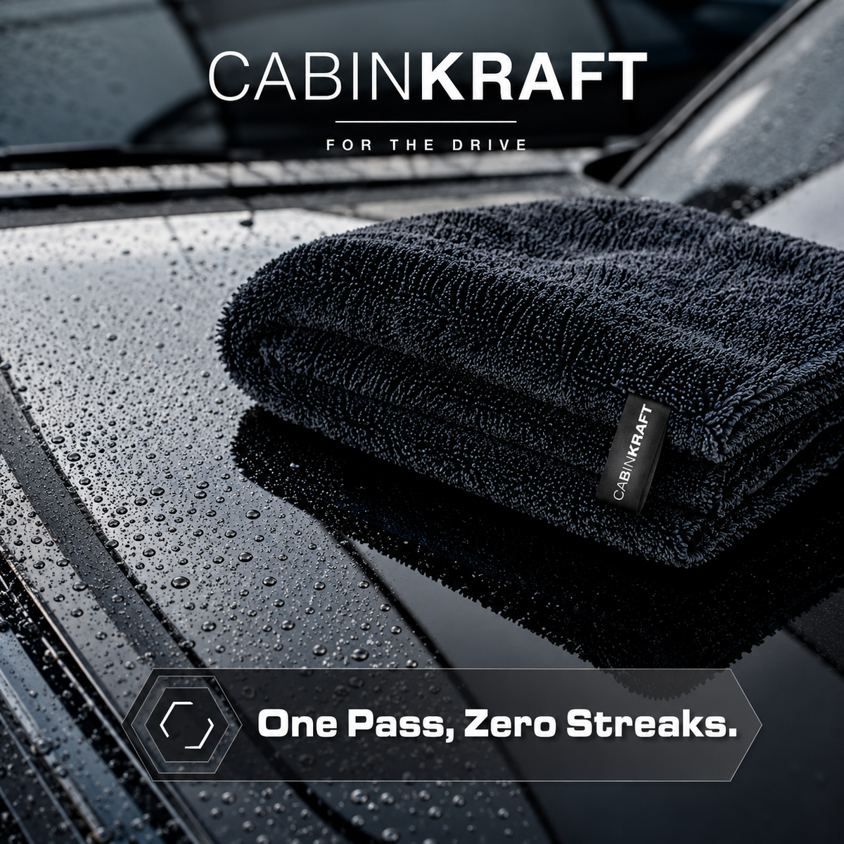 Drying towel absorbing water sheet off wet car hood
